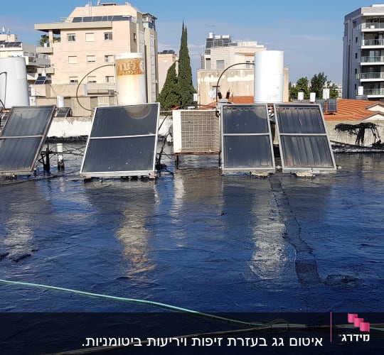 גג אטום בזפת עם דודי שמש וקולטים